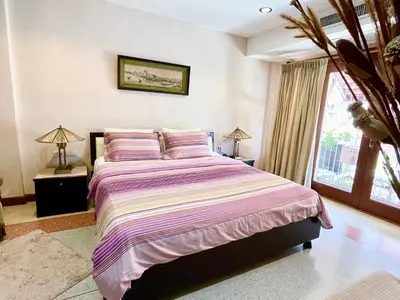 a bedroom with a bed and a window at WiNNiNE Cozy Home in Bangkok