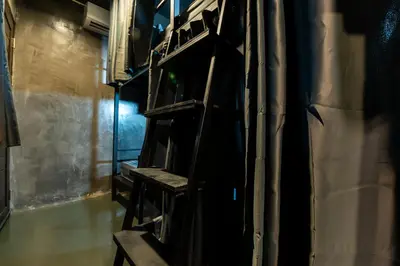 a dark room with wooden shelves in a building at Another High Away Hostel - Bangkok in Nonthaburi