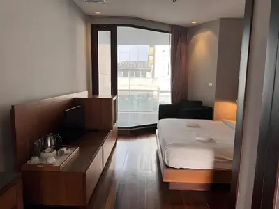 a hotel room with a bed and a window at XX Wish Inn Silom Decho Road - วิช อินน์ สีลม เดโช in Bangkok
