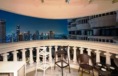 a balcony with chairs and a view of the city at 2 bedroom state tower Sathorn in Bangkok