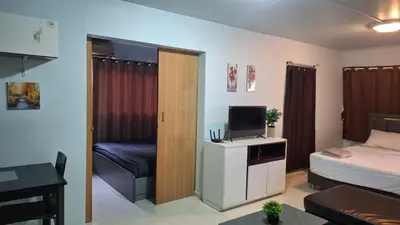 a room with a bedroom with a bed and a television at Popular Muang Thong Condo, Building C5 in Ban Bang Phang