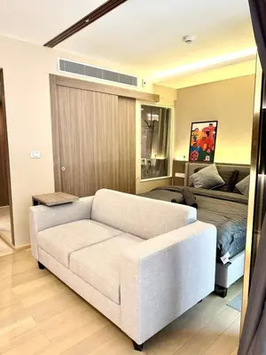 a living room with a white couch and a bed at BTS Thong Lor Downtown Low-rise Large Studio #Private Courtyard Super Large Pool in Bangkok