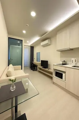 a living room with a couch and a kitchen at Thonglor Central Low rise Condominium in Bangkok
