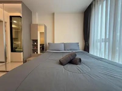 a bedroom with a large bed with two pillows on it at Thonglor Central Low rise Condominium in Bangkok
