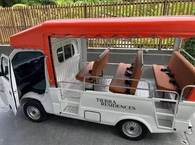 a white and red golf cart with chairs and tables at Thonglor Central Low rise Condominium in Bangkok