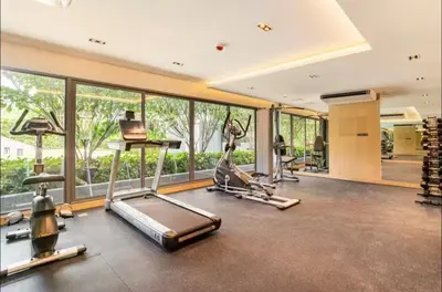a gym with cardio equipment and large windows at Thonglor Central Low rise Condominium in Bangkok