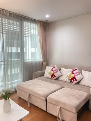 a living room with a couch and a large window at 'City Retreat' Asok Sukhumvit 23 Room 53 sqm in Bangkok