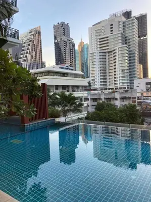 a large swimming pool in a city with tall buildings at 'City Retreat' Asok Sukhumvit 23 Room 53 sqm in Bangkok