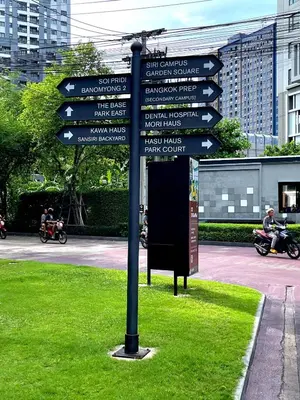 a pole with many street signs in the grass at Octopus Suite on HighRise, Skytrain, Fast Wifi and AC in Amphoe Phra Khanong