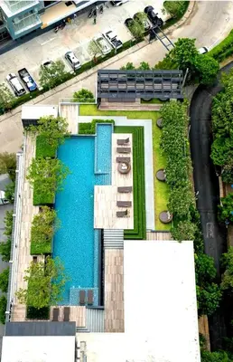 a building with a swimming pool next to a street at Immaculate Quite Resort Home, brand new ACsWiFi in Amphoe Phra Khanong