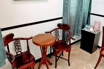 a room with two chairs and a wooden table and two chairs at xxThe Character Yaowarat Mrt Wat Mangkon Station - เดอะคาแรคเตอร์ เยาวราช สถานีวัดมังกร in Bangkok