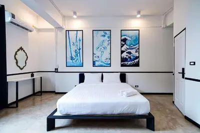 a bedroom with a bed and some paintings on the wall at xxThe Character Yaowarat Mrt Wat Mangkon Station - เดอะคาแรคเตอร์ เยาวราช สถานีวัดมังกร in Bangkok