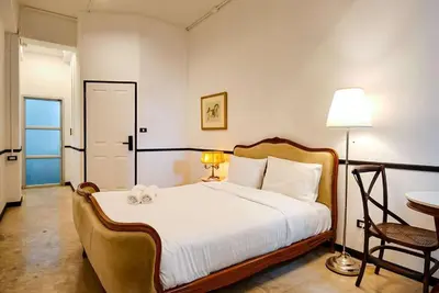 a bedroom with a bed and a chair and a table at xxThe Character Yaowarat Mrt Wat Mangkon Station - เดอะคาแรคเตอร์ เยาวราช สถานีวัดมังกร in Bangkok