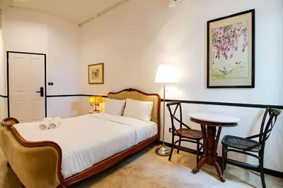 a bedroom with a bed and a table and chairs at xxThe Character Yaowarat Mrt Wat Mangkon Station - เดอะคาแรคเตอร์ เยาวราช สถานีวัดมังกร in Bangkok