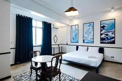 a bedroom with a bed and a table and a table and chairs at xxThe Character Yaowarat Mrt Wat Mangkon Station - เดอะคาแรคเตอร์ เยาวราช สถานีวัดมังกร in Bangkok