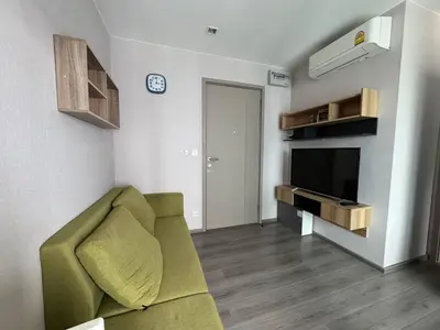 a living room with a green couch and a television at Luxury Riverside condo in Nonthaburi