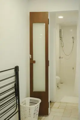 a bathroom with a toilet and a door with a mirror at Big unit for 8 people, city center Silom in Bangkok