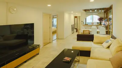 a living room with a couch and a tv at Big unit for 8 people, city center Silom in Bangkok