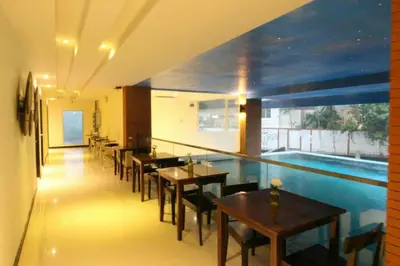 a restaurant with tables and a swimming pool at Leelawadee Modern Resort Huaykwang - ลีลาวดี ห้วยขวาง in Bangkok
