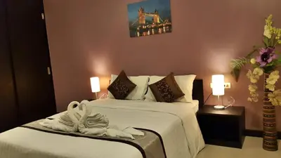 a hotel room with two beds with towels on them at Leelawadee Modern Resort Huaykwang - ลีลาวดี ห้วยขวาง in Bangkok