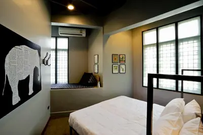 a bedroom with a bed and two windows at Bangkok Bed and Bike in Bangkok