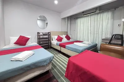 a room with two beds with red and blue at Sunshiny-BB Hostel near Punnavithi BTS station in Bangkok