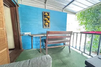 a blue wall with a table and a chair on a balcony at Sunshiny-BB Hostel near Punnavithi BTS station in Bangkok