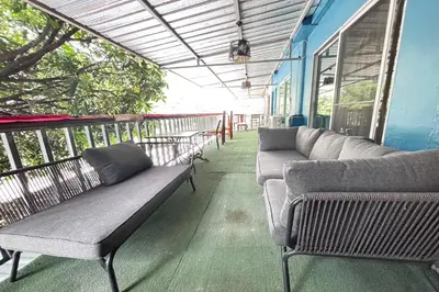 a porch with two couches sitting on a balcony at Sunshiny-BB Hostel near Punnavithi BTS station in Bangkok