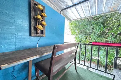a bench on a balcony with a blue wall at Sunshiny-BB Hostel near Punnavithi BTS station in Bangkok