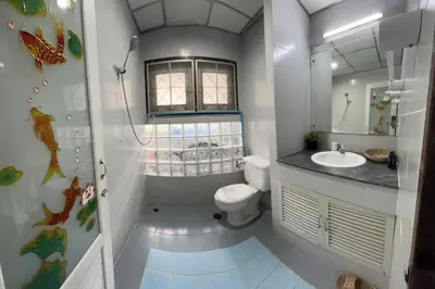 a bathroom with a toilet and a sink and a mirror at Sunshiny-BB Hostel near Punnavithi BTS station in Bangkok