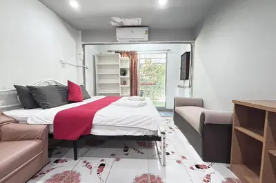 a bedroom with a bed and a couch at Sunshiny-BB Hostel near Punnavithi BTS station in Bangkok