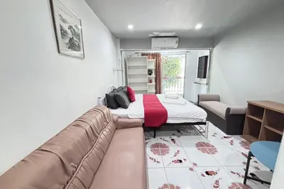 a living room with a couch and a bed at Sunshiny-BB Hostel near Punnavithi BTS station in Bangkok