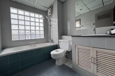 a bathroom with a toilet and a tub and a sink at Sunshiny-BB Hostel near Punnavithi BTS station in Bangkok