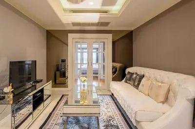 a living room with a white couch and a tv at High-Floor City View Near SIAM in Bangkok