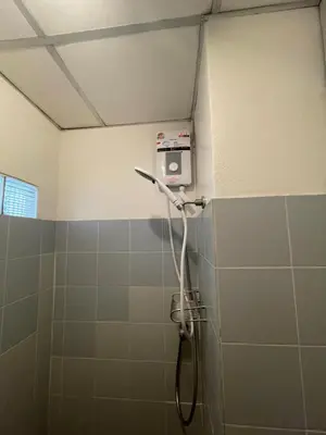 a shower in a bathroom with green tiles at Sairin 1 bedroom BTS Udomsuk in Bangna