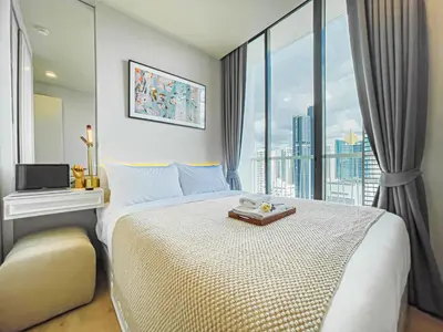 a bedroom with a large bed with a large window at CBD Living 2 BR ︱Prime Sukhumvit ︱Walk to BTS Asok & MRT SKV ︱UltraWi-Fi in Bangkok