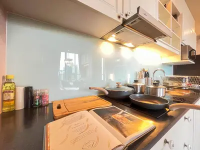 a kitchen with two frying pans on a counter at CBD Living 2 BR ︱Prime Sukhumvit ︱Walk to BTS Asok & MRT SKV ︱UltraWi-Fi in Bangkok