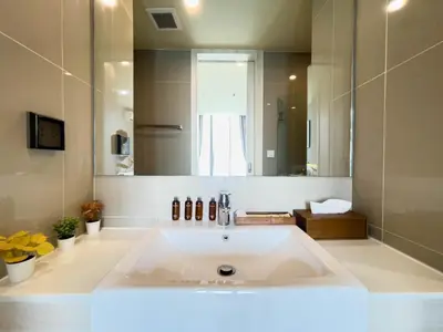 a bathroom with a large sink and a mirror at CBD Living 2 BR ︱Prime Sukhumvit ︱Walk to BTS Asok & MRT SKV ︱UltraWi-Fi in Bangkok