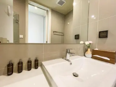 a bathroom with a sink and a large mirror at CBD Living 2 BR ︱Prime Sukhumvit ︱Walk to BTS Asok & MRT SKV ︱UltraWi-Fi in Bangkok
