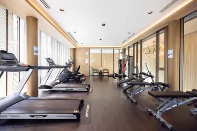 a gym with a row of treadmills and ellipticals at Chambers cher ratchada ramintra in Ban Baen Phichit