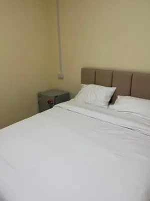 a large bed with white sheets and a pillow at UOKResort in Ban Khlong Yuan