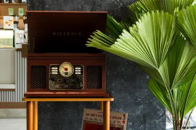 an old radio sitting on a table next to a plant at 5loft Anti-Hotel, Silom, Bangkok in Bangkok