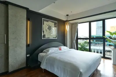a bedroom with a large bed and a large window at 5loft Anti-Hotel, Silom, Bangkok in Bangkok