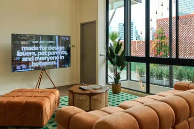 a living room with a couch and a large screen at 5loft Anti-Hotel, Silom, Bangkok in Bangkok