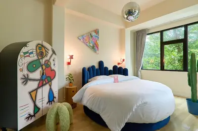 a bedroom with a large bed with a painting on the wall at 5loft Anti-Hotel, Silom, Bangkok in Bangkok