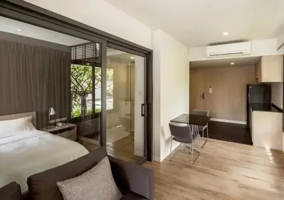 a bedroom with a bed and a desk and a kitchen at Bangkok Tryp in Bangkok