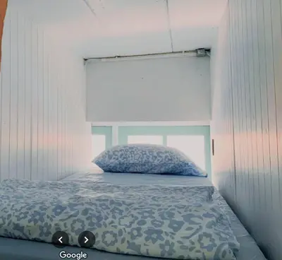 a bedroom with a bed with a pillow on it at The Hide Out Rambuttri Hostel in Bang Bua Thong Railway Station