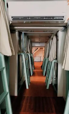 a walkway in a closet with clothes on racks at The Hide Out Rambuttri Hostel in Bang Bua Thong Railway Station