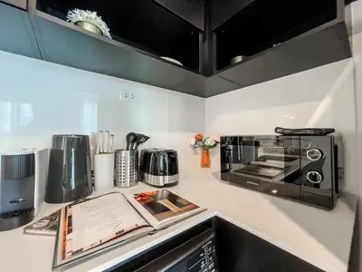 a kitchen counter with a toaster oven and a microwave at Luxury 2BR︱Fast WiFi︱Walk to Central & MRT Rama 9 in Bangkok