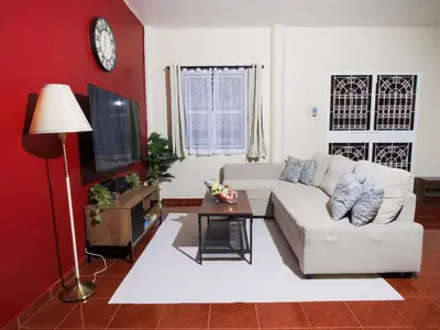 a living room with a white couch and a tv at Cozy House 2BR BTS Ekkamai in Bangkok